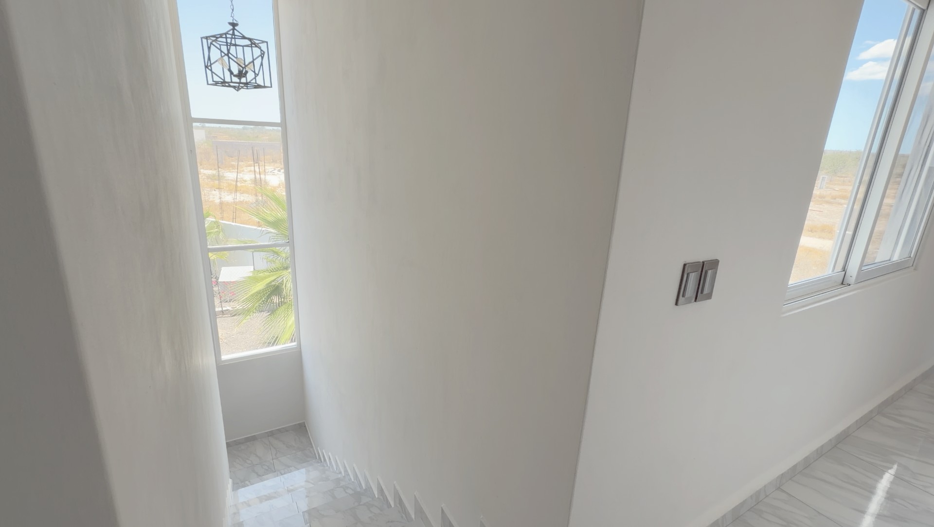 Stair hall with tall window and hanging lantern